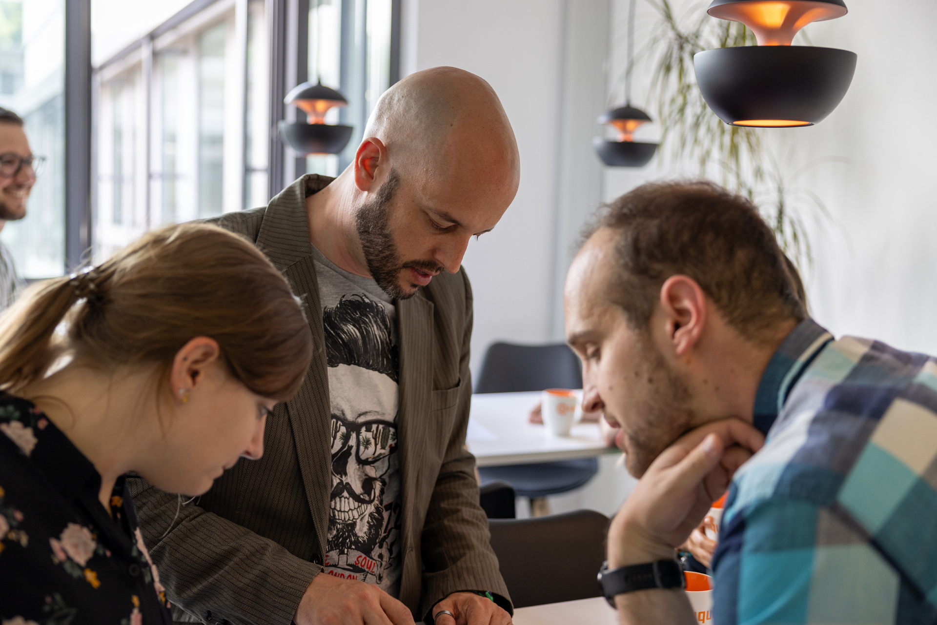 iqual Mitarbeitende stehen an einem Tisch